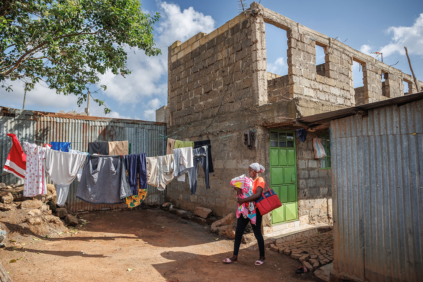 First-time mother Esther Gathoni walks home from her postnatal check-up in Machakos County. Esther signed-up for PROMPTS early in her pregnancy, and has been using the service ever since to guide her around newborn care, nutrition, and family planning.