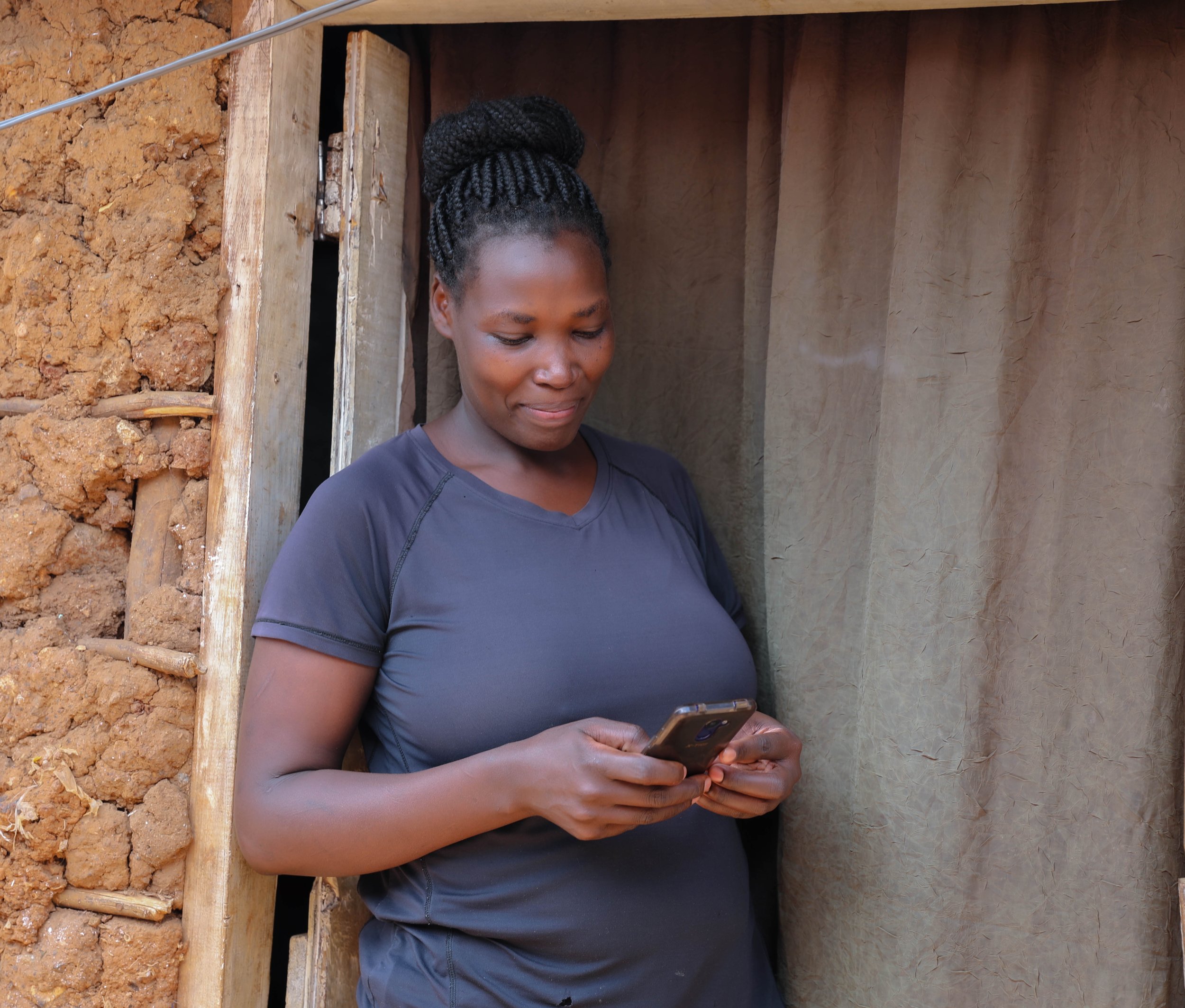 Lilian stands outside her home in Kibera, a large informal settlement in Nairobi. She signed up for PROMPTS when pregnant with her third child, and quickly found that it not only a channel for advice and information during pregnancy, but somewhere she could report on her experiences of care - both clinical and respectful - in her local health facility. ‘I give my feedback so women in my community have a better chance of giving birth safely.’ she says.