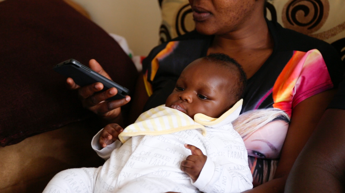 A mother checks her phone for SMS messages from Jacaranda Health s digital health service PROMPTS